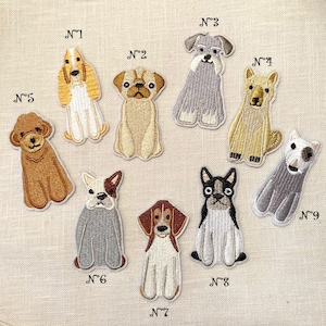 Puede incluir: Nueve parches bordados para planchar que representan diferentes razas de perros. Los parches están numerados del 1 al 9. Los perros están en varias poses, incluyendo sentados, de pie y acostados. Los parches son de diferentes colores, incluyendo marrón, blanco, negro y gris.