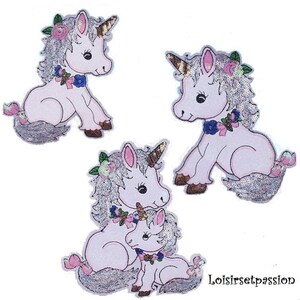 May include: Three sparkly pink unicorn iron-on patches with silver glitter and floral details. The largest patch features a mother and baby unicorn.