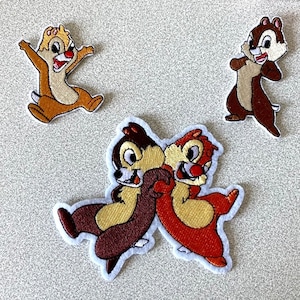 Peut inclure: Trois patchs brodés thermocollants représentant Tic et Tac de la série animée de Disney, Tic et Tac, les rangers du risque. Un patch montre Tic et Tac en train de se faire un câlin, un autre montre Tic seul et le troisième montre Tac seul.