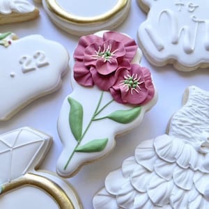 May include: A set of six decorated sugar cookies featuring a floral design, a ring, a dress, and the date "27.22".