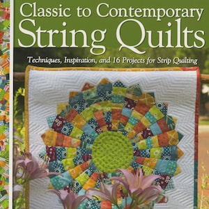 May include: A book titled "Classic to Contemporary String Quilts" with a colorful quilt design on the cover. The quilt is made of strips of fabric in various colors and patterns. The book is about techniques, inspiration, and 16 projects for strip quilting.