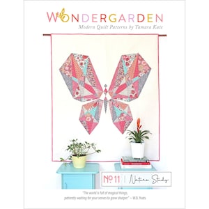 May include: A quilt pattern featuring a geometric butterfly design in shades of pink, teal, and white. The pattern is titled "Nature Study" and is part of the Wondergarden collection of modern quilt patterns by Tamara Kate.