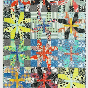 May include: A colorful patchwork quilt with a repeating starburst pattern. The quilt features squares with various patterned fabrics in shades of blue, red, yellow, and black. The text "AARDVARK QUILTS" is at the bottom.