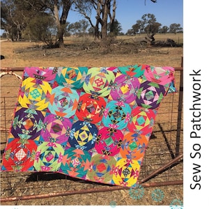 May include: A colorful patchwork quilt with a pineapple design. The quilt is made of various fabrics in shades of pink, green, yellow, blue, and orange. The quilt is draped over a rusty metal fence. The text "Perfect Pineapples Sew & Fold Throw Rug" is at the top of the image. The text "Sew So Patchwork" is on the right side of the image. The text "Lynne Wilson designs" is at the bottom of the image.