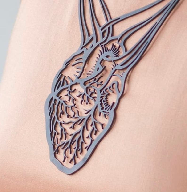 May include: A black anatomical heart necklace with intricate details. The necklace is made of a lightweight material and features a delicate chain.