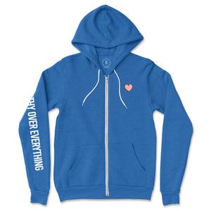 May include: A blue zip-up hoodie with a hood and white drawstring. The left sleeve has the text "THY OVER EVERYTHING" printed vertically in white. A small peach-colored heart is on the chest. The hoodie has a small "S" tag.