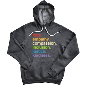 May include: A dark grey hooded sweatshirt with a rainbow-colored print of the words "love, empathy, compassion, inclusion, justice, kindness."