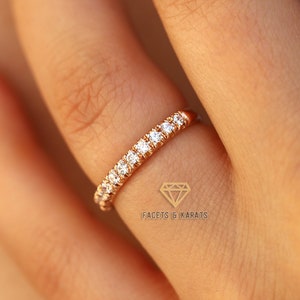 Puede incluir: Un delicado anillo de banda de oro con una fila de pequeños diamantes transparentes engastados en pavé.