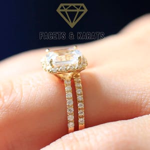 Puede incluir: Un anillo de oro con una gema grande de corte cuadrado rodeada de piedras más pequeñas. La banda presenta una doble fila de pequeñas piedras brillantes. El texto "FACETS & KARATS" es visible.
