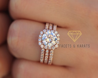 May include: A rose gold engagement ring set with a large, round, centre stone surrounded by a halo of smaller stones. The ring is set with three bands, each with a row of smaller stones.