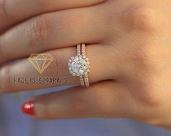 May include: A rose gold engagement ring set with a large, round, centre stone surrounded by a halo of smaller stones. The band is a simple, thin band with a row of small stones.