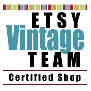 May include: A white background features the words "ETSY Vintage TEAM" in black and teal lettering. Below, the text "Certified Shop" is in black. A colourful striped border is at the top.