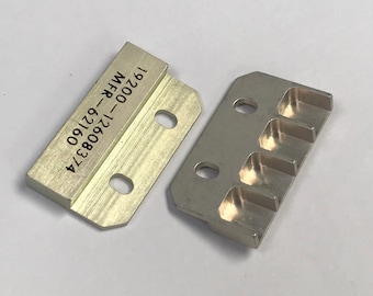 May include: Two silver-colored metal brackets with rounded corners and drilled holes. One bracket has the text "19200-12608374 MFR-62160" printed on it. The other bracket has three recessed slots.