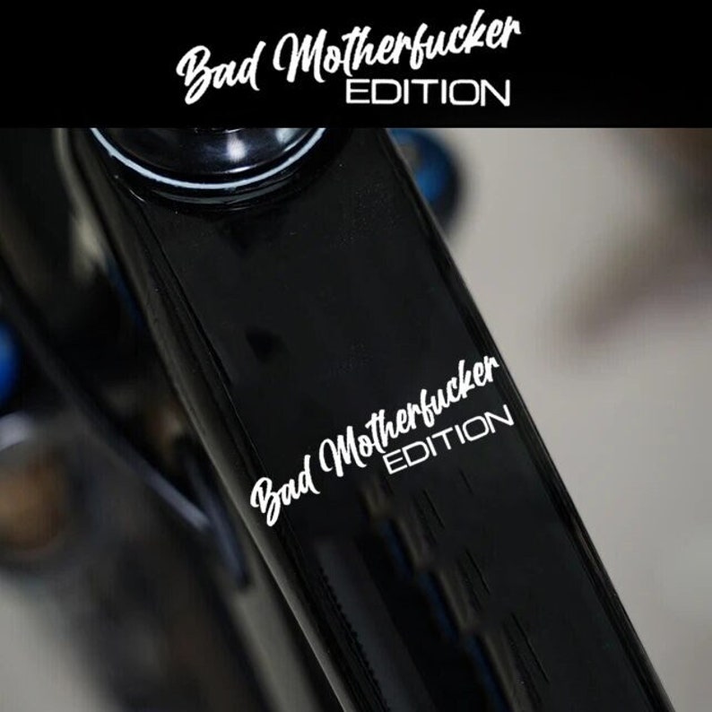 Puede incluir: Un cuadro de bicicleta negro con una pegatina blanca que dice "Bad Motherfucker Edition".