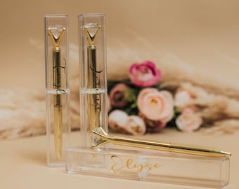 May include: Three gold pens with diamond-shaped tops in clear plastic boxes. The pens are engraved with the names "Taylor", "Jazza", and "Elyssa".