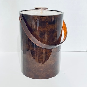 Op de afbeelding: Een bruine en witte ijs emmer met een houten handvat. De emmer heeft een glanzende afwerking en een wit deksel met een doorzichtige knop.