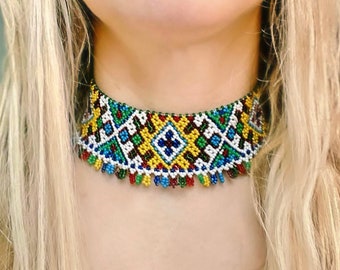 May include: A colorful beaded choker necklace with a geometric pattern in shades of blue, green, yellow, red, and white.