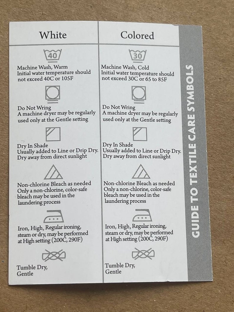 May include: A white card with black text and symbols outlining care instructions for white and coloured clothing. The card includes instructions for washing, drying, bleaching, ironing, and tumble drying. The card also includes the text "Guide to Textile Care Symbols".