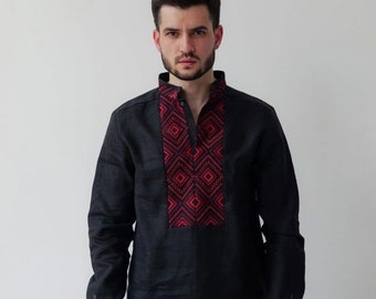 Peut inclure: Une chemise en lin noire avec un motif brodé rouge et noir sur le devant. La chemise a des manches longues et un col boutonné.