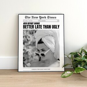 Może przedstawiać: Czarno-biały wydruk w stylu gazety z nagł&oacute;wkiem "New Report Shows Better Late Than Ugly" i zdjęciem kobiety w okularach przeciwsłonecznych i białym ręczniku na głowie. Tekst "Looking this good takes time!" znajduje się na dole wydruku.