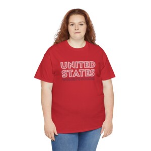 K&ouml;nnte beinhalten: Ein rotes T-Shirt mit einer wei&szlig;en Grafik, auf der "UNITED STATES WOMEN'S SOCCER" in einer Retro-Schrift steht.