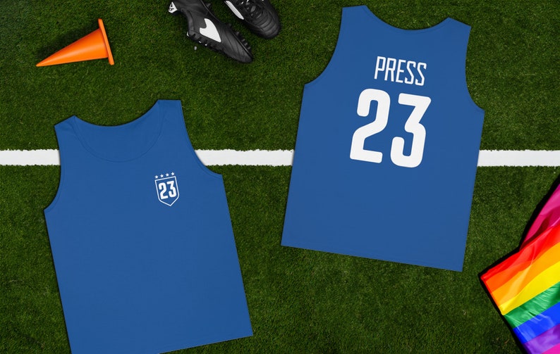 May include: Blue sleeveless jersey with the number 23 and the word "PRESS" on the back. The front of the jersey has a white shield with the number 23 and five stars.