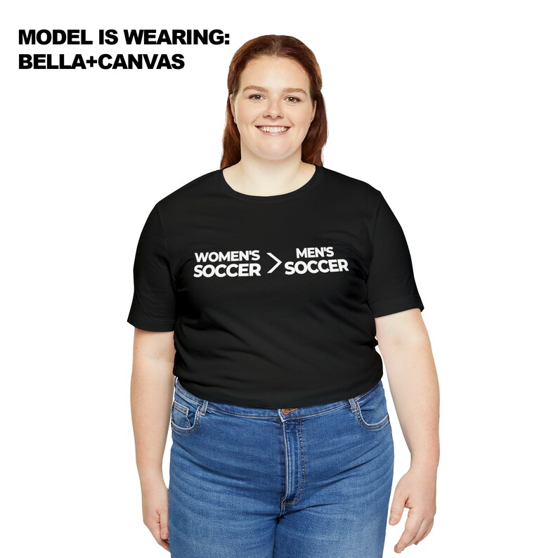 May include: A black t-shirt with white text that reads "Women's Soccer > Men's Soccer".