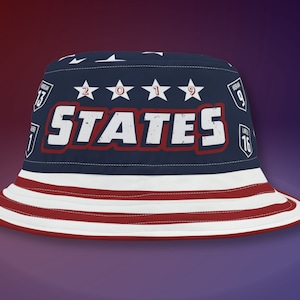May include: A blue bucket hat with a red, white, and blue American flag design. The hat has the word "STATES" in white letters with a red outline and the year "2019" in white stars.