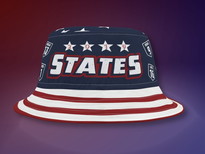May include: A blue bucket hat with a red, white, and blue American flag design. The hat has the word "STATES" in white letters with a red outline and the year "2019" in white stars.