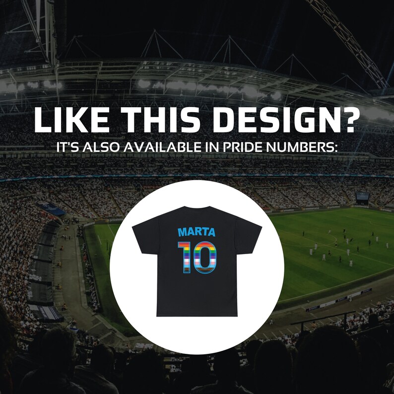 May include: Black soccer jersey with the name "Marta" and the number "10" in rainbow colors on the back. The jersey is displayed against a blurred background of a stadium.