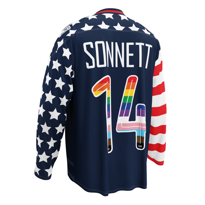 May include: A navy blue hockey jersey with a white star pattern on the sleeves. The back of the jersey has the name "SONNETT" and the number "14" in rainbow colors.