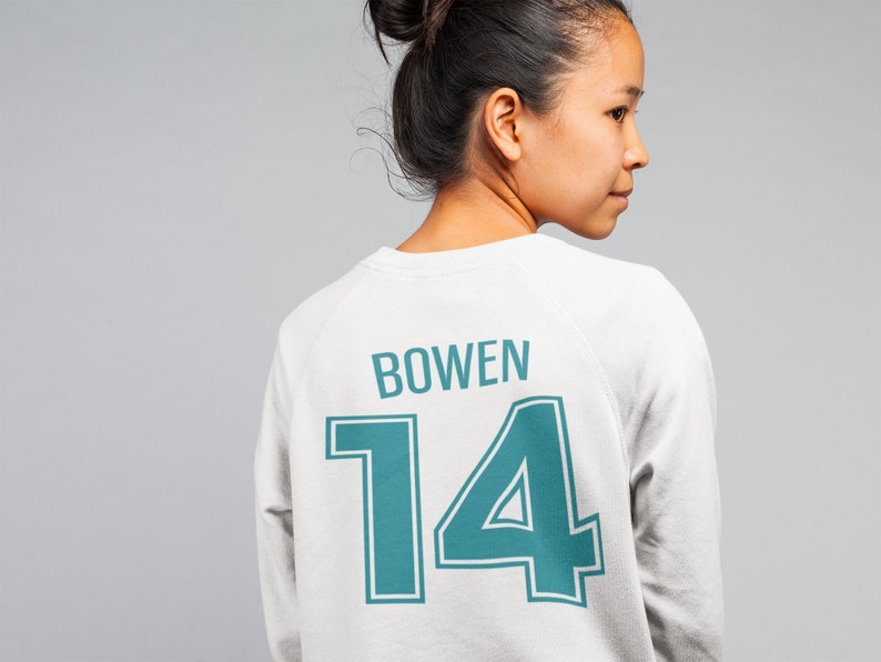 May include: White sweatshirt with a teal blue number "14" and the name "BOWEN" printed on the back.
