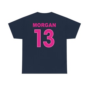 May include: A navy blue t-shirt with the name "MORGAN" and the number "13" printed on the back in pink.