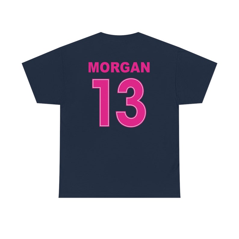 May include: A navy blue t-shirt with the name "MORGAN" and the number "13" printed on the back in pink.