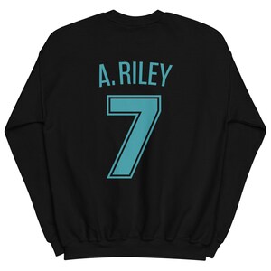 May include: Black sweatshirt with a teal blue design on the back. The design includes the text "A. RILEY" and the number "7".
