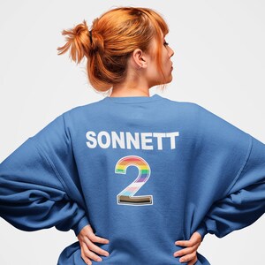 May include: A royal blue sweatshirt with the word "SONNETT" and the number "2" printed on the back. The number is outlined in black and filled with a rainbow color scheme.