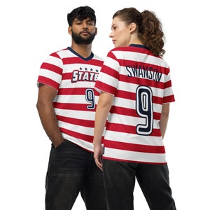 May include: Two people wearing red and white striped soccer jerseys with the number 9 on the back. The jersey on the left has the word "STATE" on the front. The jersey on the right has the name "SWANSON" on the back.
