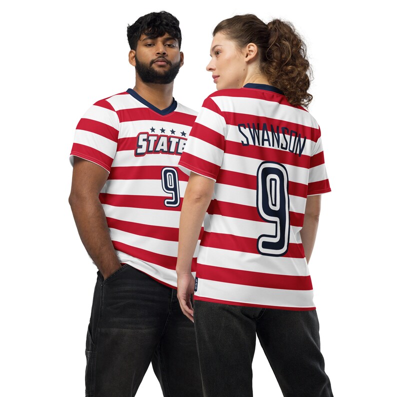 May include: Two people wearing red and white striped soccer jerseys with the number 9 on the back. The jersey on the left has the word "STATE" on the front. The jersey on the right has the name "SWANSON" on the back.