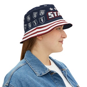 May include: A blue and red bucket hat with a white star and the word "STAR" printed on the front. The hat also features a design of various numbers and words on the front.