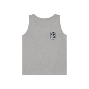May include: A gray sleeveless tank top with a navy blue embroidered shield featuring the number 15 and five stars.