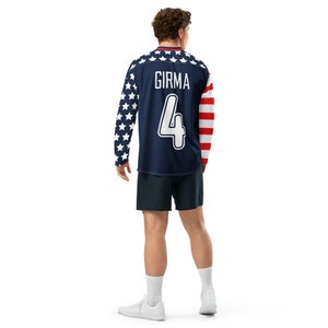 May include: A navy blue long-sleeved soccer jersey with a white star pattern on the sleeves. The jersey has the name "GIRMA" and the number "4" printed on the back in white.