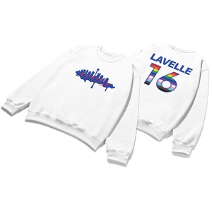 May include: White sweatshirt with a blue Seattle skyline graphic on the front and the name "Lavelle" and the number "16" with a rainbow and transgender pride flag on the back.