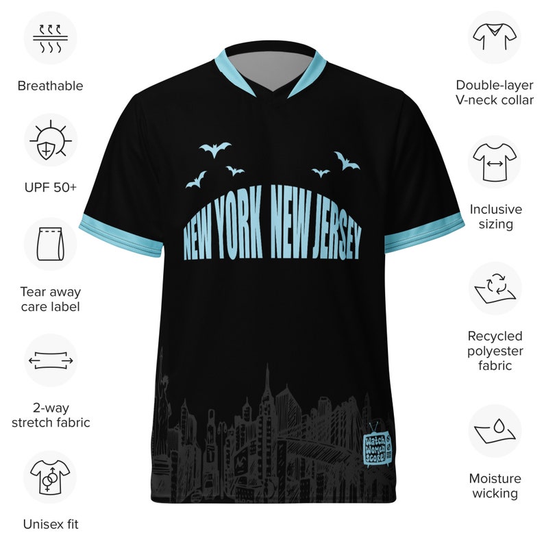 K&ouml;nnte beinhalten: Schwarzes Trikot mit blau-wei&szlig;em Design mit dem Text "New York New Jersey". Das Trikot hat einen V-Ausschnitt und eine Stadtbildgrafik am unteren Rand.