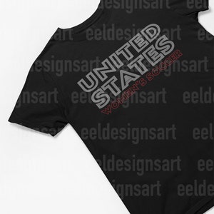 K&ouml;nnte beinhalten: Schwarzes T-Shirt mit einem wei&szlig;en Grafikdesign, auf dem in einer stilisierten Schrift "UNITED STATES WOMEN'S SOCCER" steht.