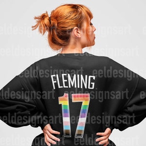 May include: Black sweatshirt with a rainbow-colored number 17 and the name "FLEMING" printed on the back.