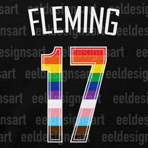 May include: A black background with the name "FLEMING" in white above the number "17". The number is filled with a rainbow gradient and the colours of the transgender pride flag.