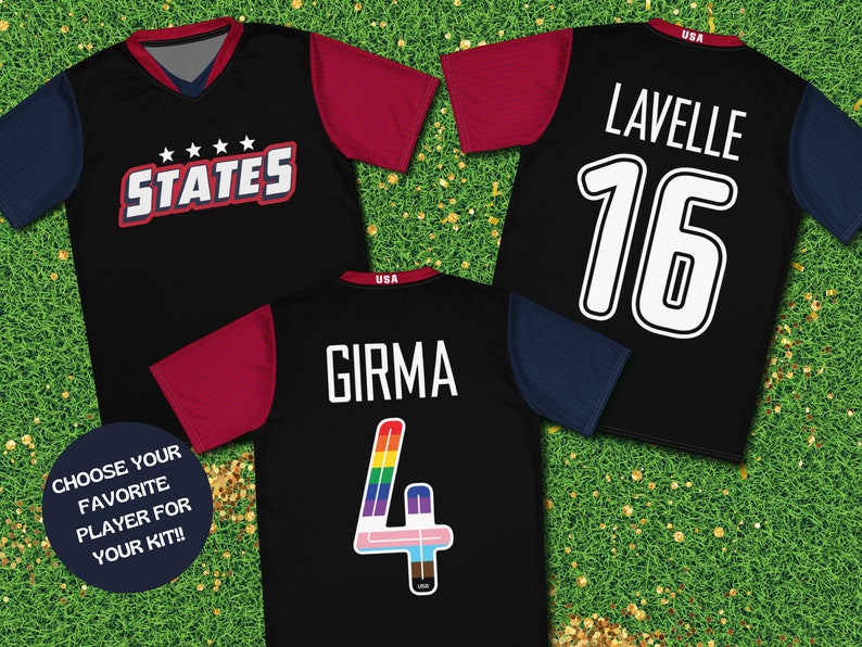 May include: Three black soccer jerseys with different player names and numbers. The jerseys have red, blue, and rainbow colored accents. The jerseys have the text "STATES" and "USA" on them. The jerseys are on a green grass background.