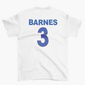 Puede incluir: Camiseta blanca con letras azules y rojas en la espalda. El texto dice "BARNES 3".
