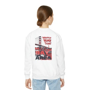 May include: White sweatshirt with a red and black graphic print of the Golden Gate Bridge and the text "Watch Women Score! Bay Area".