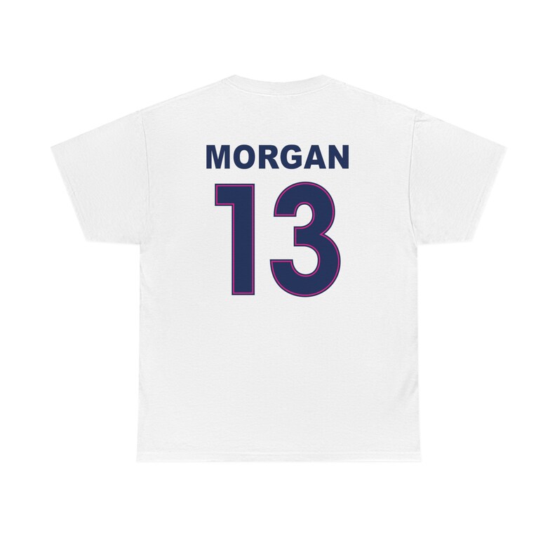 May include: White t-shirt with the name "MORGAN" and the number "13" printed on the back in navy blue with a pink outline.